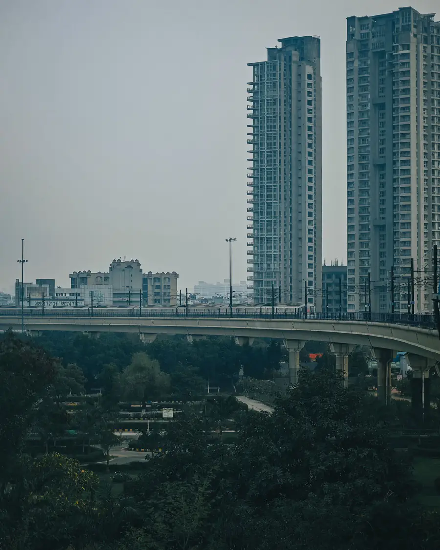 Gurgaon high-rise towers under a dusty, hazy sky