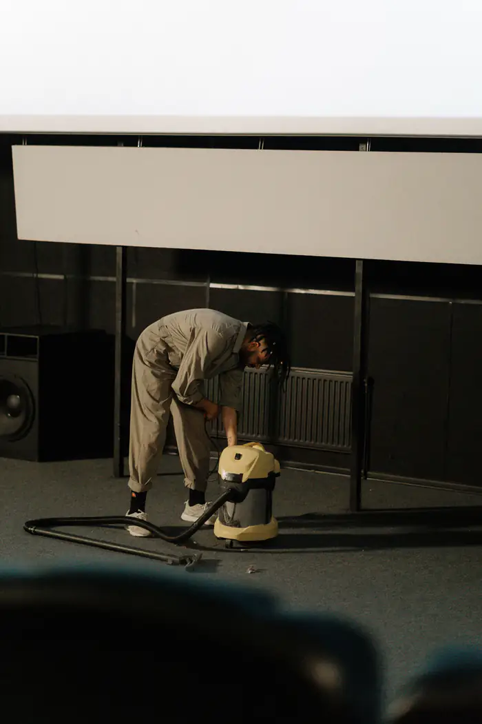 Technician running an industrial vacuum across an office floor