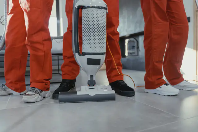 Uniformed cleaning team using an upright vacuum for office deep cleaning