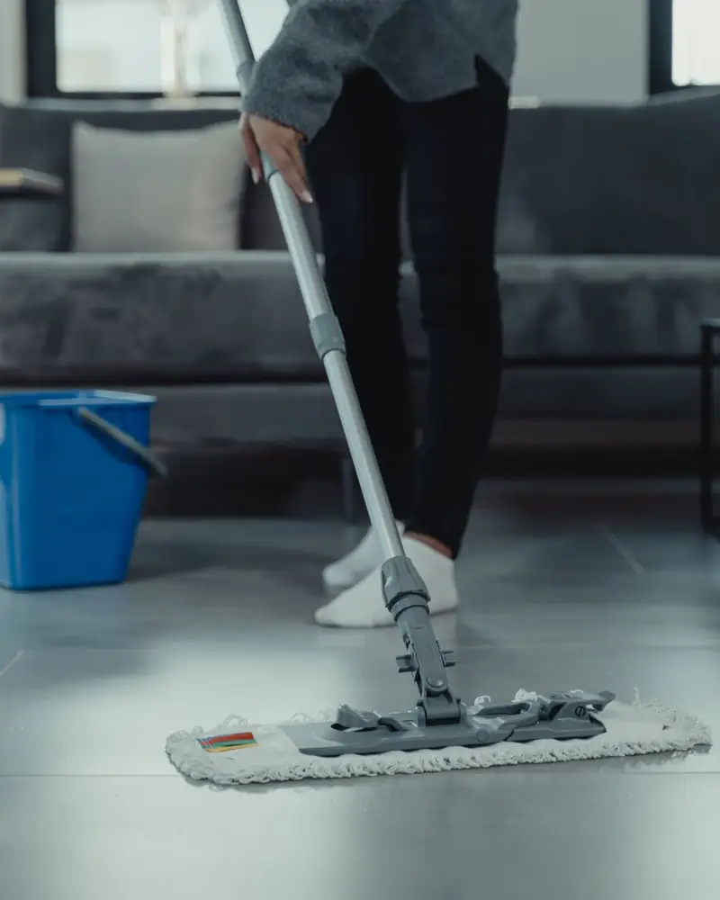 Regular flat mop cleaning the surface of a tiled floor