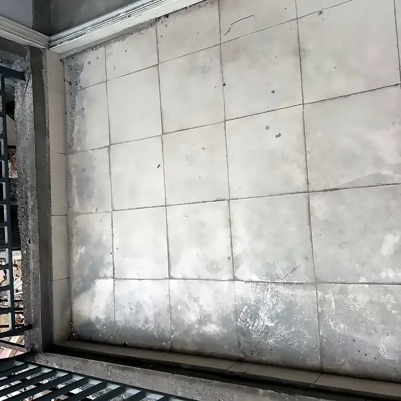 Construction dust and cement residue on floor tiles before machine scrubbing